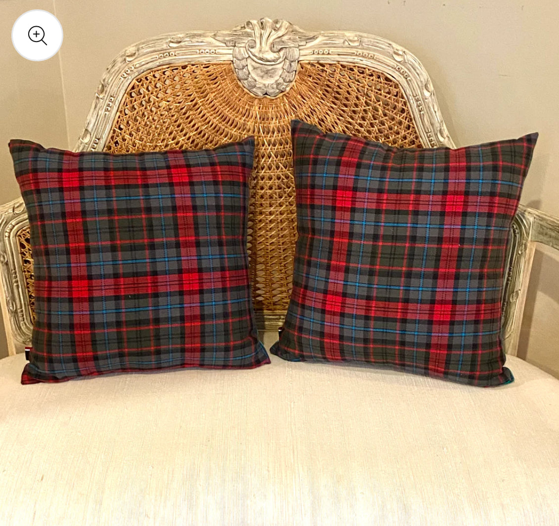 Pair of vivid traditional with a twist plaid and crest throw pillows.