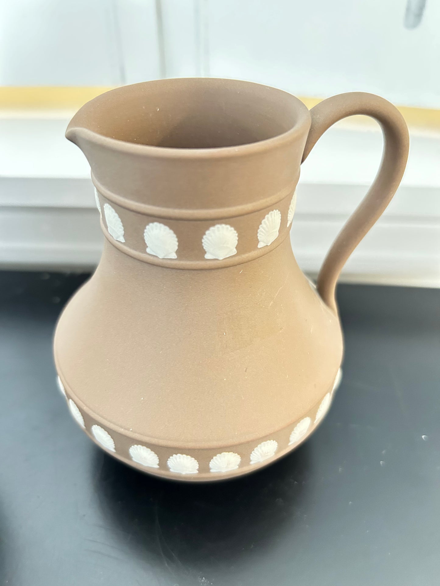 Wedgwood Pitcher with white Shells on a Brown Backround 5” tall