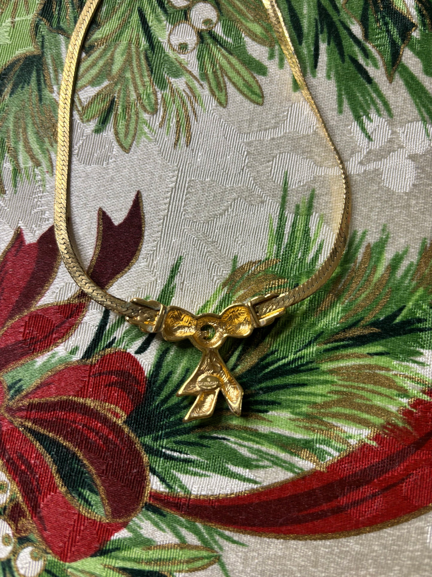 Stunning vintage Givenchy gold plated herringbone chain necklace with a crystal bow pendant!