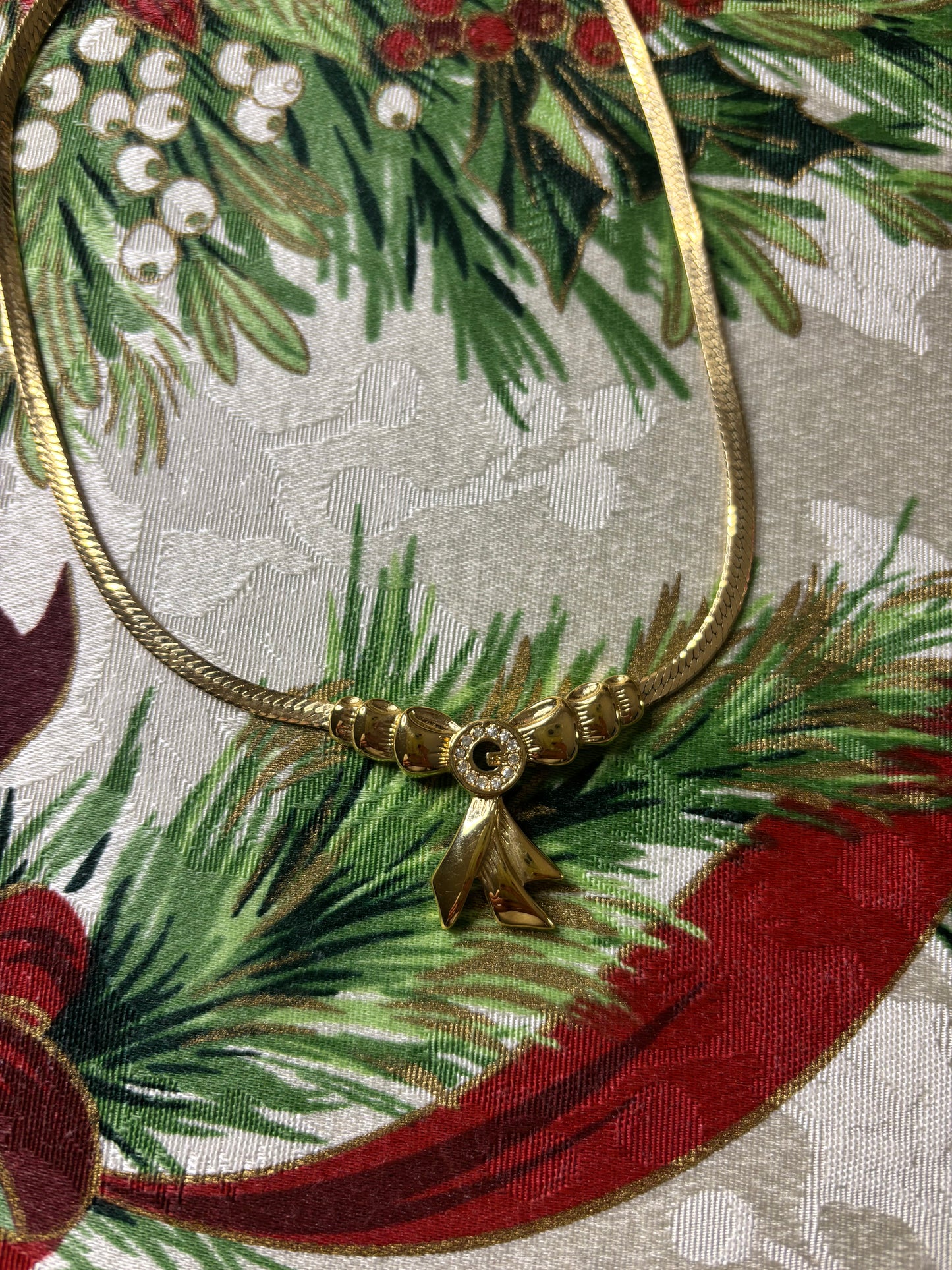 Stunning vintage Givenchy gold plated herringbone chain necklace with a crystal bow pendant!