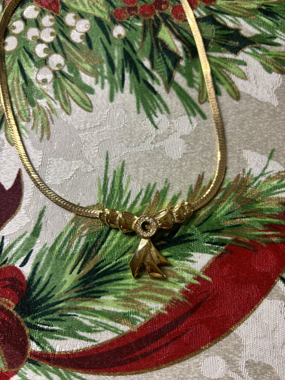 Stunning vintage Givenchy gold plated herringbone chain necklace with a crystal bow pendant!