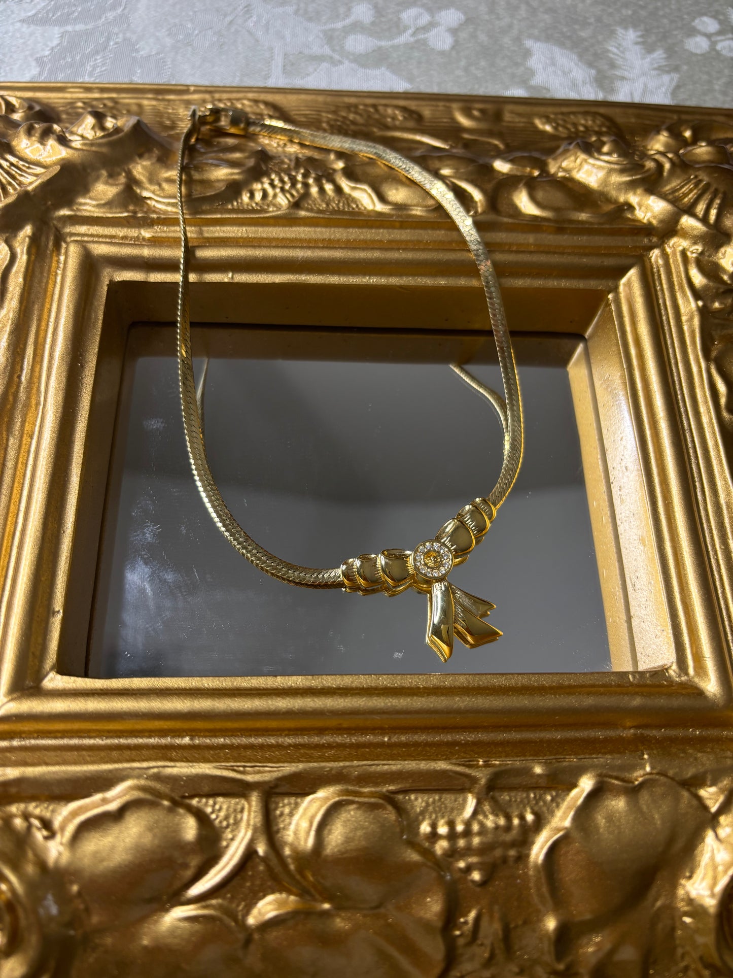 Stunning vintage Givenchy gold plated herringbone chain necklace with a crystal bow pendant!