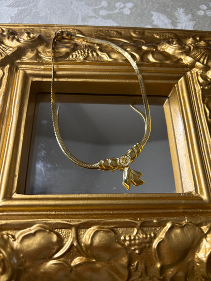 Stunning vintage Givenchy gold plated herringbone chain necklace with a crystal bow pendant!