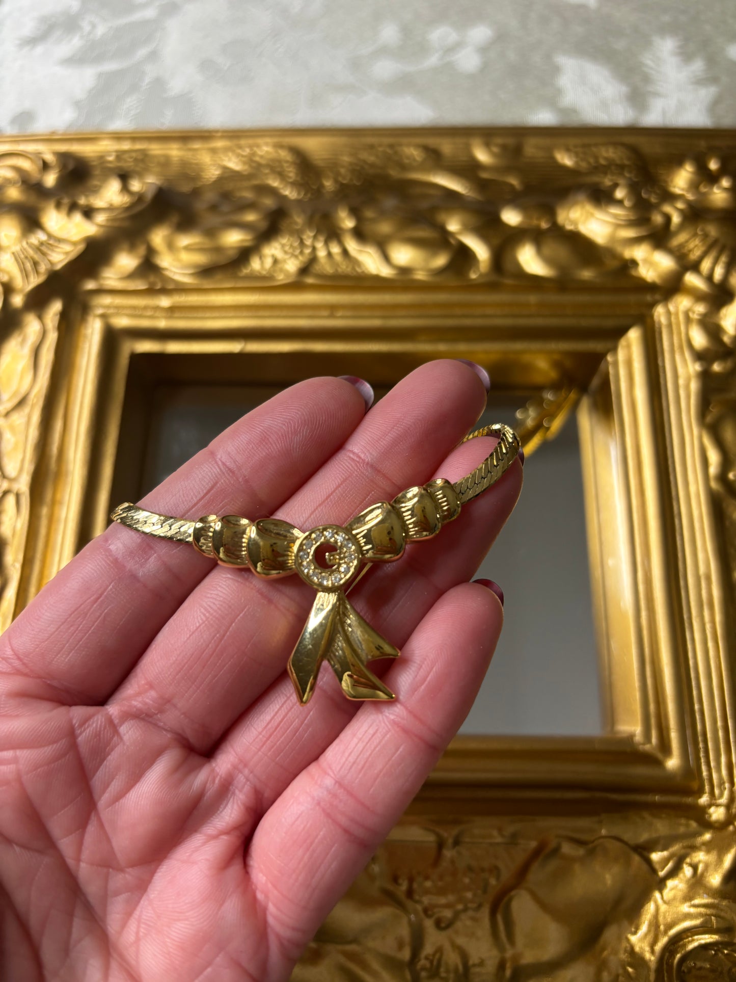 Stunning vintage Givenchy gold plated herringbone chain necklace with a crystal bow pendant!