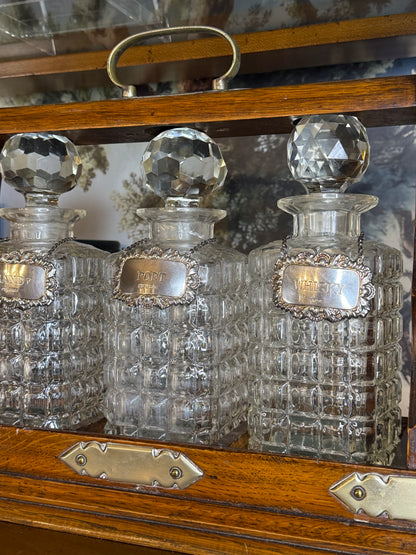 Antique English Oak Three-Bottle Tantalus W/ Cut Crystal Decanters, Sterling Silver Labels & Original Key, c.1900, 15” W x 13” H x 6.5” D