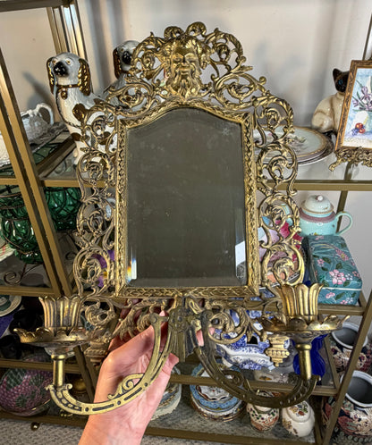 Stunning Bradley & Hubbard antique brass beveled wall mirror featuring a Bacchus figural motif and attached candle sconces!