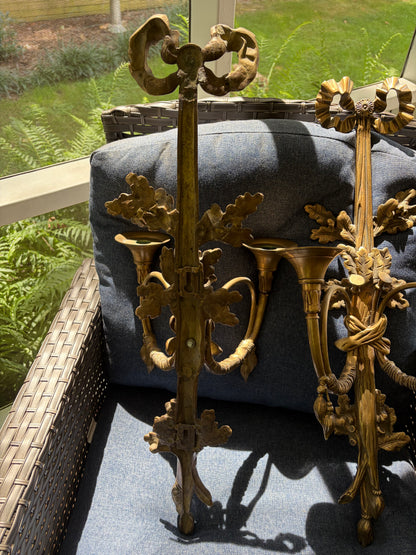 Stunning antique pair of French Louis XVI style brass wall sconces with bows, tassels, and horn motif designs!