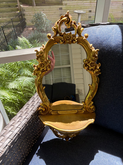 Beautiful Syroco wall mirror with an integrated shelf featuring an ornate gilt gold frame!