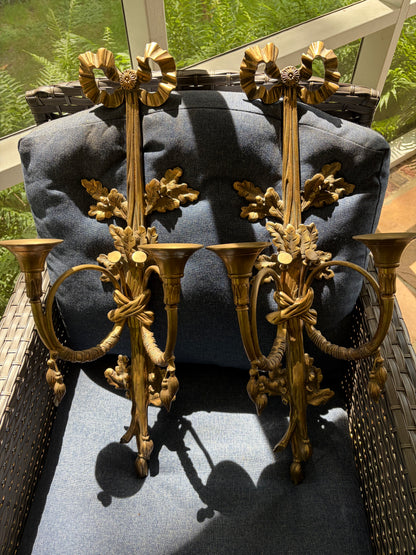 Stunning antique pair of French Louis XVI style brass wall sconces with bows, tassels, and horn motif designs!