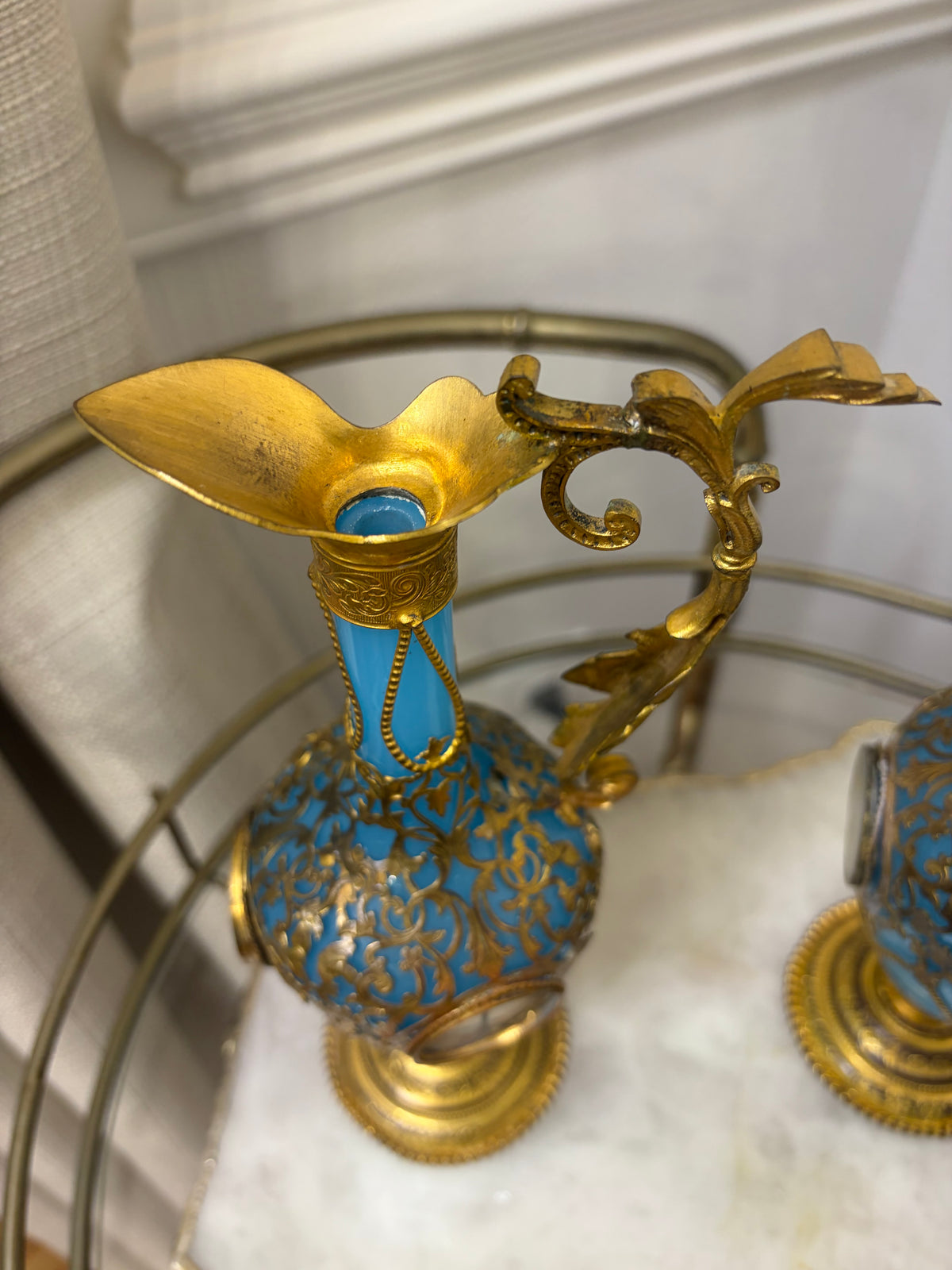 Stunning antique 19th-century French Napoleon III-style blue opaline glass ewer jugs pair adorned with elaborate gilt ormolu (gold-plated bronze) mounts, scrollwork, and scenic medallions! Circa 1836-1850