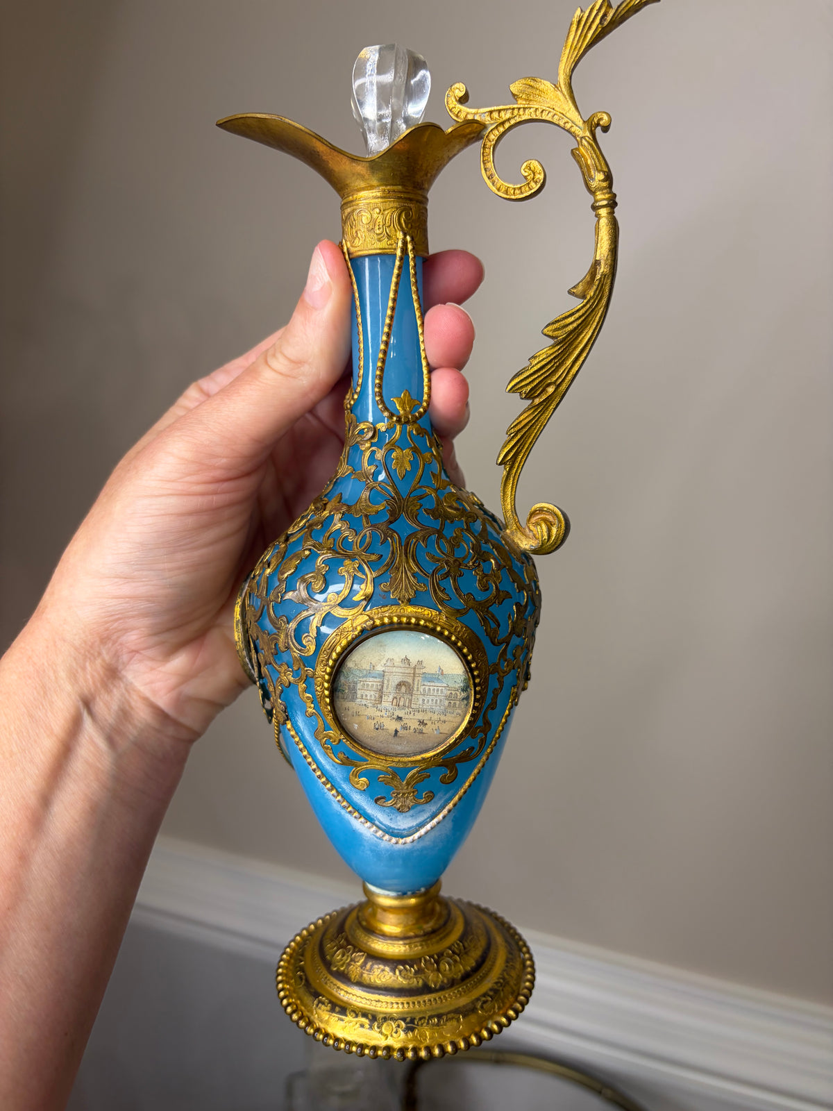 Stunning antique 19th-century French Napoleon III-style blue opaline glass ewer jugs pair adorned with elaborate gilt ormolu (gold-plated bronze) mounts, scrollwork, and scenic medallions! Circa 1836-1850