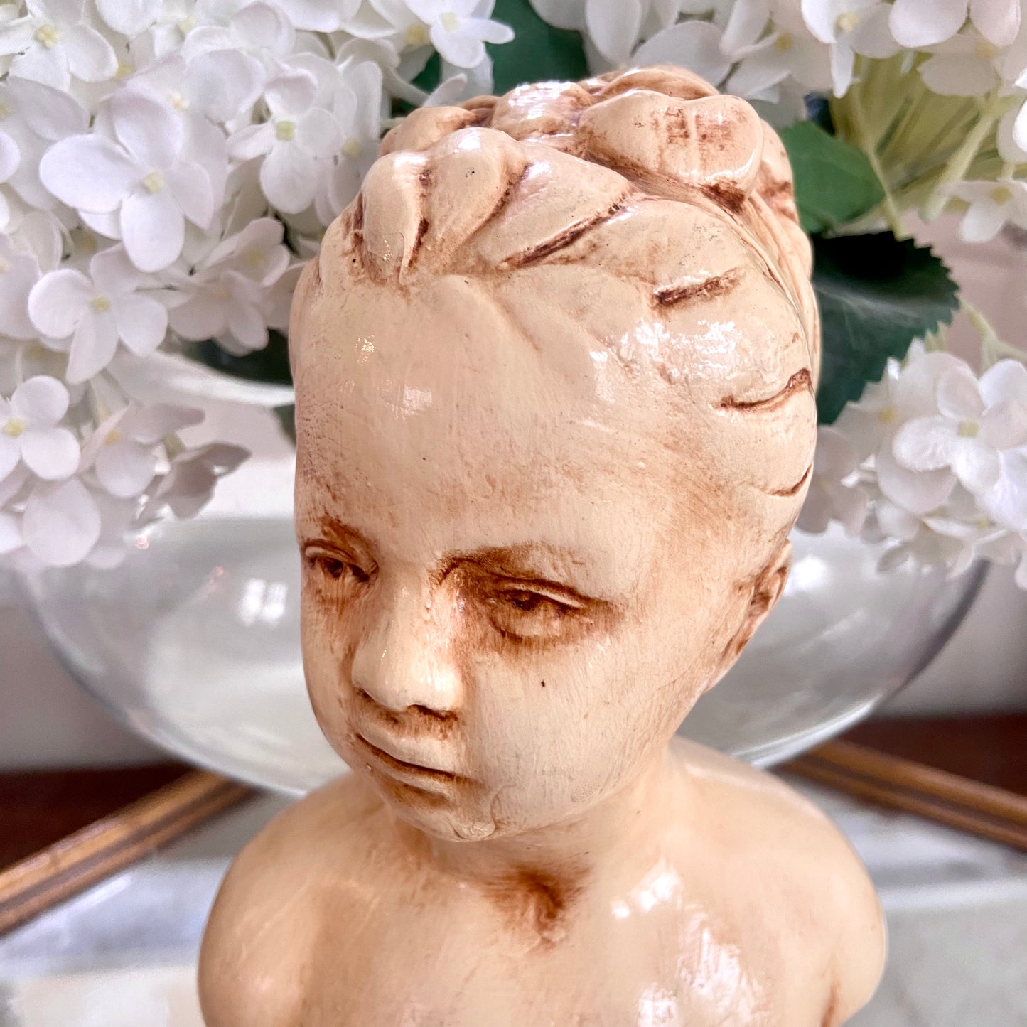 Lovely vintage statue bust of young woman with a bow in antique ivory .